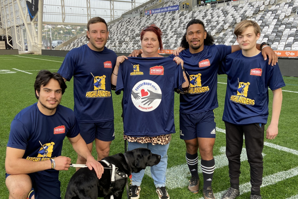 Highlanders players (Josh Timu, Mitch Hunt and Folau Fakatava) join Foster Hope Otago Coordinator Juanita Willems and son to showcase the co-branded t-shirts provided by Chemist Warehouse as part of their fundraiser. 
